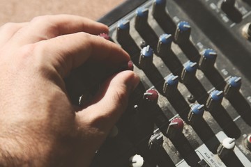 A sound engineer turning an equalization knob on an old mixing console. Music production concept...