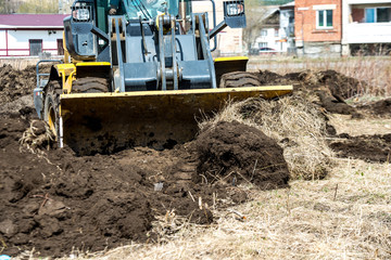 bulldozer pushes the ground, tractor pushes a lump of soil, preparing the area for construction