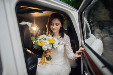 Stylish happy bride inside of retro car. Emotional moment. 