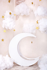 Stylish vintage children's room with a wooden moon and textile clouds. Children location for a photo shoot. Moon with stars and clouds dreamy decor. Stylish vintage children's room with a wooden moon 