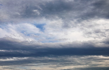 Dramatic dark clouds on blue sky background and texture