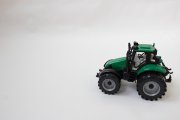 Small metal childrens toy tractor on a light background