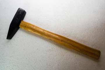 A hammer with a wooden handle on a white background close-up.