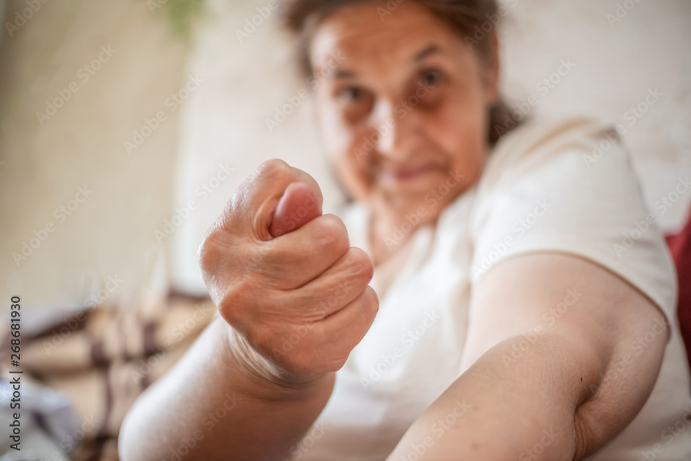 Wall mural Old woman shows hand gestures Fig