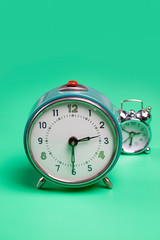 Retro alarm clock on green background