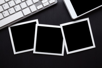 Classic paper photo frames, mobile phone and computer keyboard on aluminum table