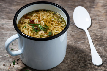 hot chicken soup with noodles in a mug