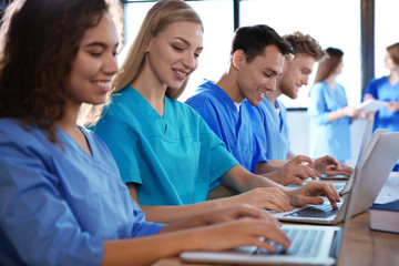 Group of smart medical students with gadgets in college