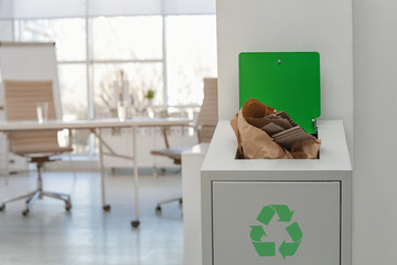 Open full trash bin in modern office, space for text. Waste recycling