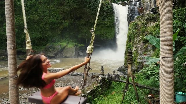Beautiful girl having fun at the waterfalls in Bali. Concept about wanderlust traveling and wilderness culture