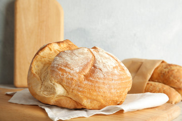 Board with fresh bread on table, closeup