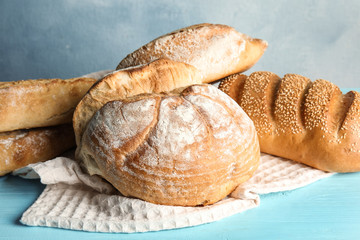 Pile of fresh bread on table against color background, closeup