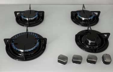 Gas burners with blue flame on modern stove