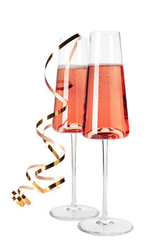 Glasses Of Rose Champagne With Gold Streamer Isolated On White