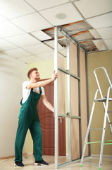 Fototapeta na wymiar Young worker installing drywall indoors. Home repair service