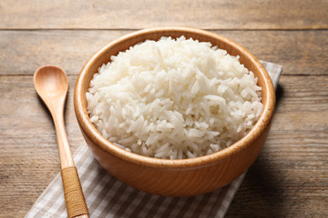 Bowl of delicious rice on wooden table
