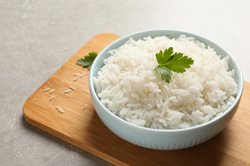 Bowl of delicious rice with parsley on table, space for text