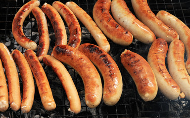 Grilling sausages on barbecue grill. Bavarian sausages.