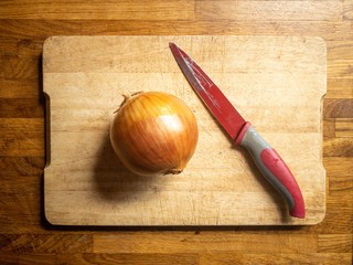 knife on a cutting board with onion
