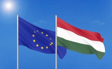 European Union vs Hungary. Thick colored silky flags of European Union and Hungary. 3D illustration on sky background. - Illustration