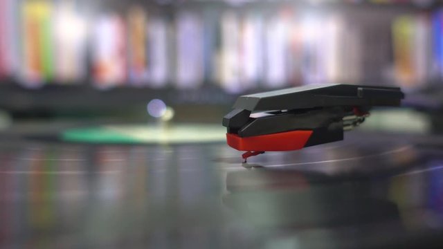 4K UHD Closeup view of a stylus motion on a gramophone vinyl LP record or a phonograph record with green label. Black musical long play album disc 12 inch 33 rpm spiral groove. Stereo sound playback.