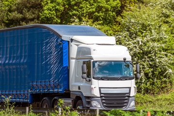 blue curtain side lorry truck on uk motorway in fast motion
