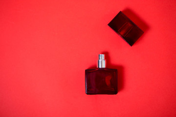 Bottle of perfume on red background