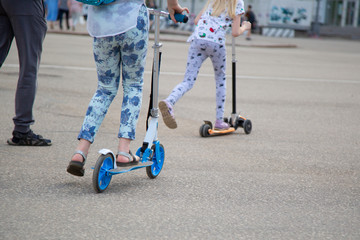 Girl on a scooter riding on the street.