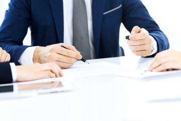 Group of business people and lawyers discussing contract papers sitting at the table, close-up. Successful teamwork, cooperation and agreement concepts