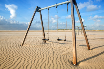 Fototapeta premium two swings in the sand by the beach