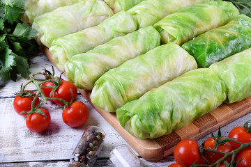 Raw cabbage rolls on the wooden board ready to be cooked