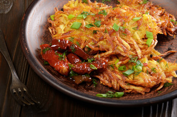 Closeup view at Homemade tasty potato pancakes in clay dish with sun-dried tomatoes