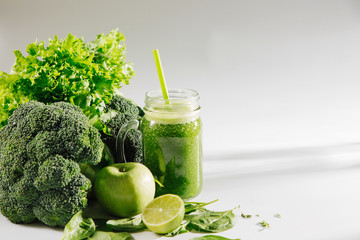 Fresh blended green smoothie in  jar on white table. Detox and diet  concept. Vegetarian food.