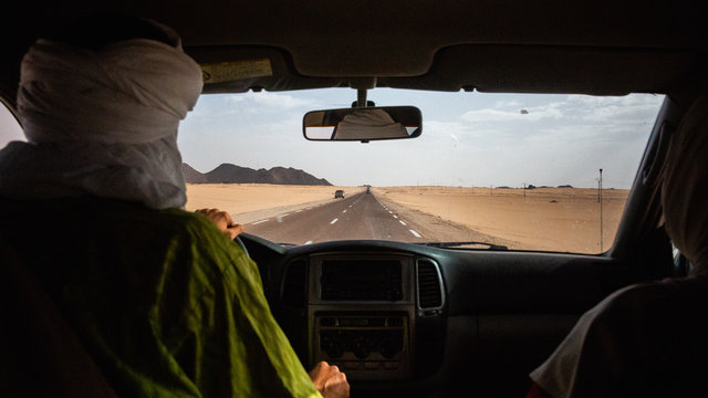 Tuareg man driving on his car through Sahara Desert