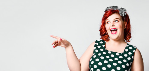 Pin up a female portrait. Beautiful retro fat woman in polka dot dress with red lips and old-style...