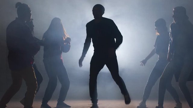 Six Caucasian rappers are performing on dark street. Unforgettable presentation.