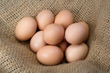 Ten eggs from a farm on burlap close up. Poultry farm, natural products.