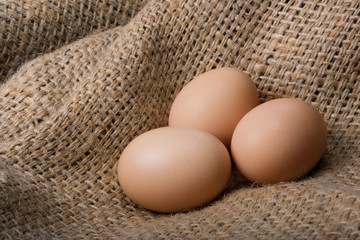 Fresh brown eggs on a bag. Natural crude products.
