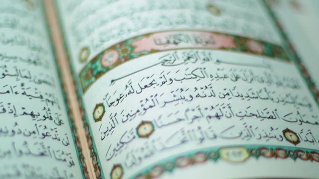 the holy Quran muslim holy book, detail of surah al kahf in slow motion 