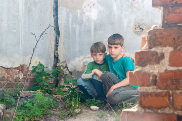 Children in an abandoned house, two poor abandoned boys, orphans as a result of natural disasters and military actions. Submission photo.