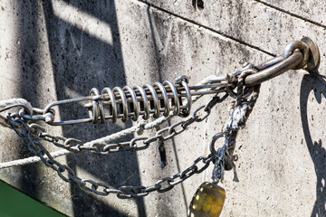 Close Up of marina mooring with shock-absorbing springs, ropes and float