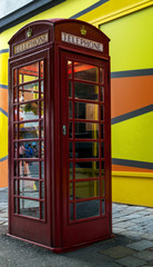 Fototapeta premium red phone booth on wall background