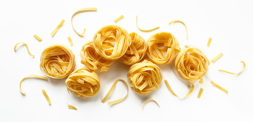 dry uncooked fettuccine on a white background