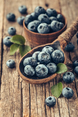Blueberries in wooden spoon on old wood table. Healthy eating and nutrition concept.