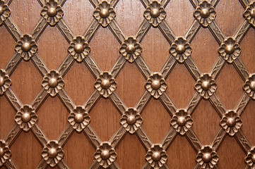 Metal golden pattern on a wooden door