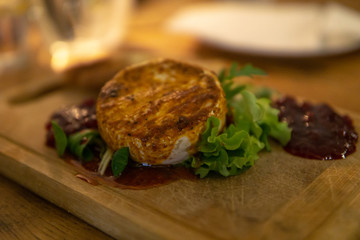 gebackener Camembert mit Salat auf Holzbrett