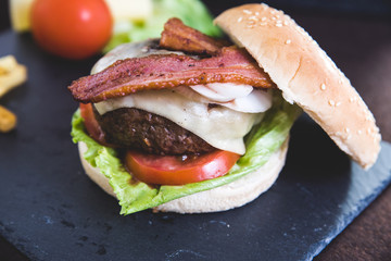 Delicious burgers with beef patty, bacon, cheese and cabbage