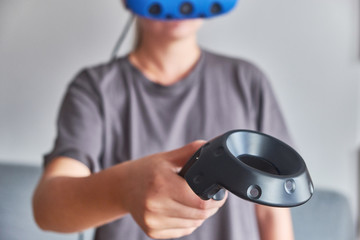 The girl in glasses of virtual reality with remote control in hand