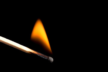 Burning match stick in darkness. Fire in the dark.