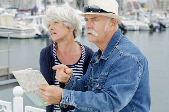 senior couple holding map and looking stressed